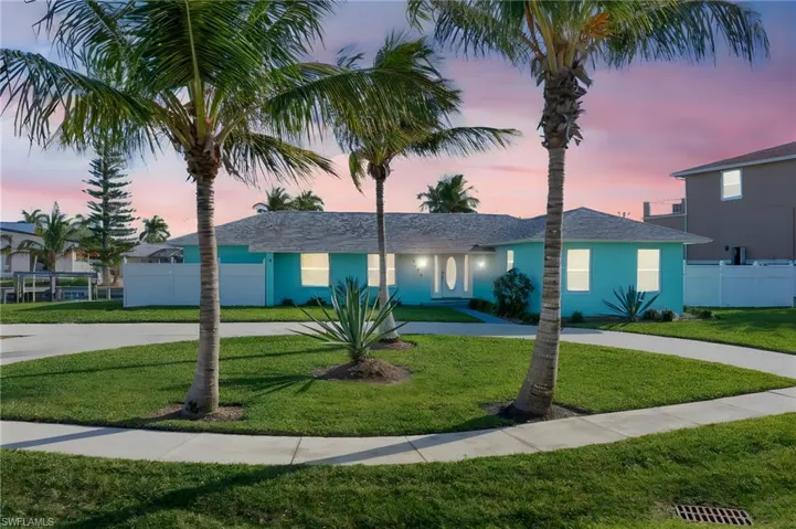 Ranch-style home featuring a yard, fence, and curved driveway