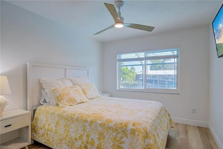 Bedroom with baseboards, wood finished floors, and a ceiling fan