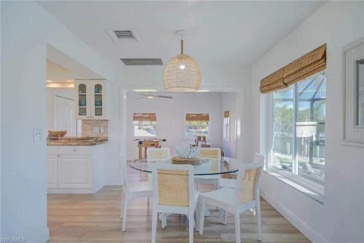 Dining area featuring a wealth of natural light, baseboards, light wood-style floors, and visible vents