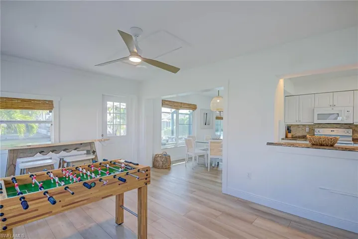Playroom featuring baseboards, a ceiling fan, and light wood finished floors