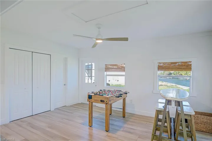 Playroom with baseboards, light wood-style flooring, and a ceiling fan