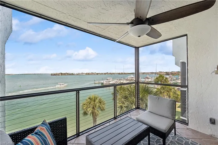 Balcony with a water view and ceiling fan