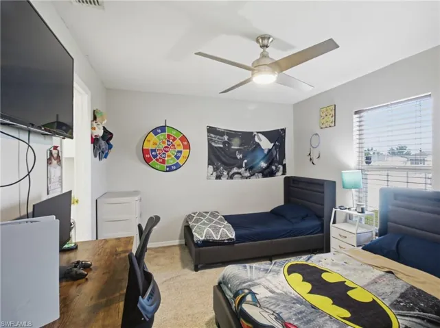 Bedroom 2 with a desk, carpet, and ceiling fan