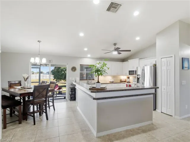 Kitchen featuring pendant lighting, white cabinetry, a chandelier, recessed lighting, and tasteful backsplash