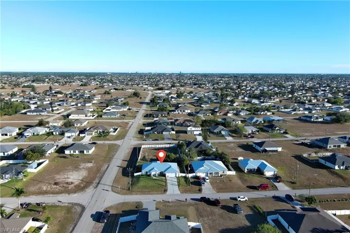 Aerial view of property and surrounding area with nearby suburban area