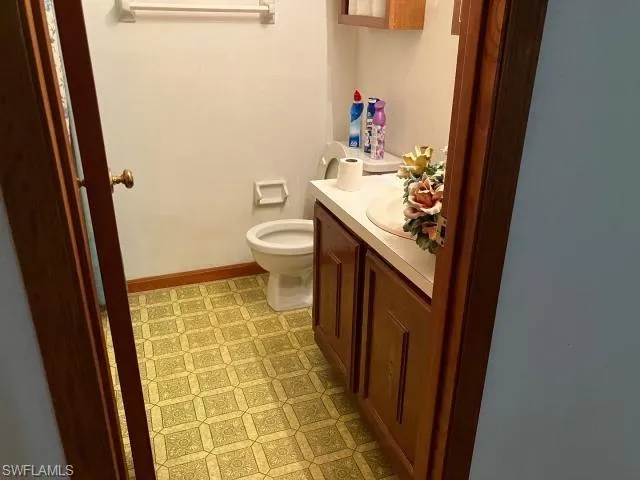 Bathroom featuring tile patterned flooring, toilet, and vanity