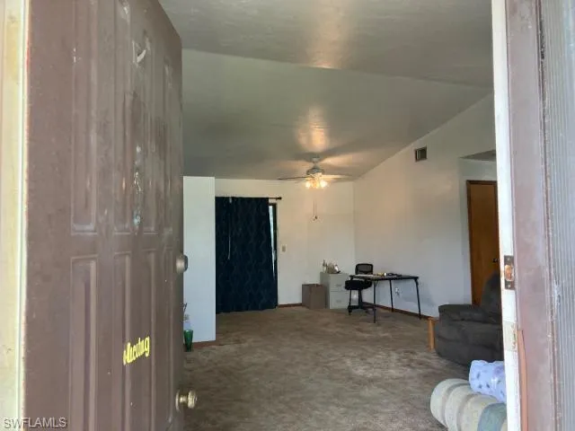 Living room with carpet floors and ceiling fan