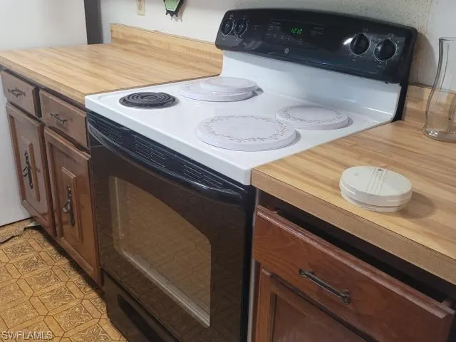 Kitchen with white range with electric cooktop and light tile patterned floors