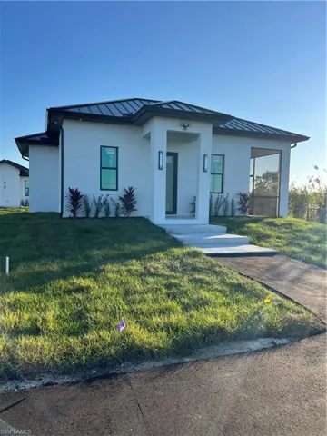 View of front of home featuring a standing seam roof, a metal roof, and a front yard