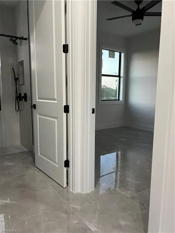 Hallway featuring light marble finish floors