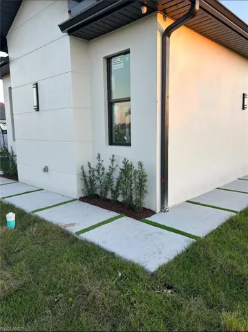 View of side of property featuring stucco siding and a lawn
