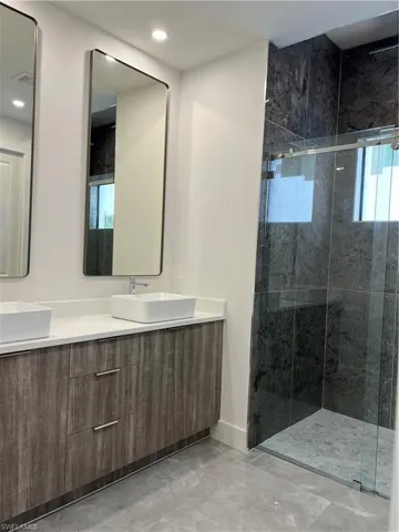 Bathroom with double vanity and a stall shower