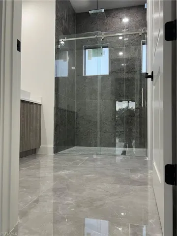 Bathroom with a marble finish shower and vanity