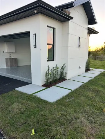 View of property exterior featuring a yard and stucco siding