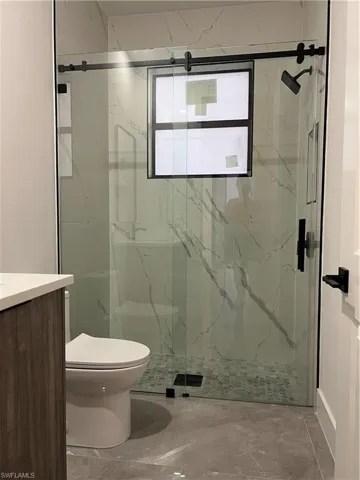 Guest house Full bath with vanity, a marble finish shower, and marble tiled floors