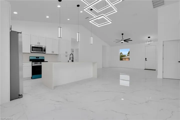 Kitchen with off-white cabinetry, stainless steel appliances, and pendant lighting over the island.
