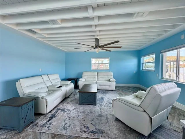 Living room with ceiling fan and dark hardwood / wood-style floors