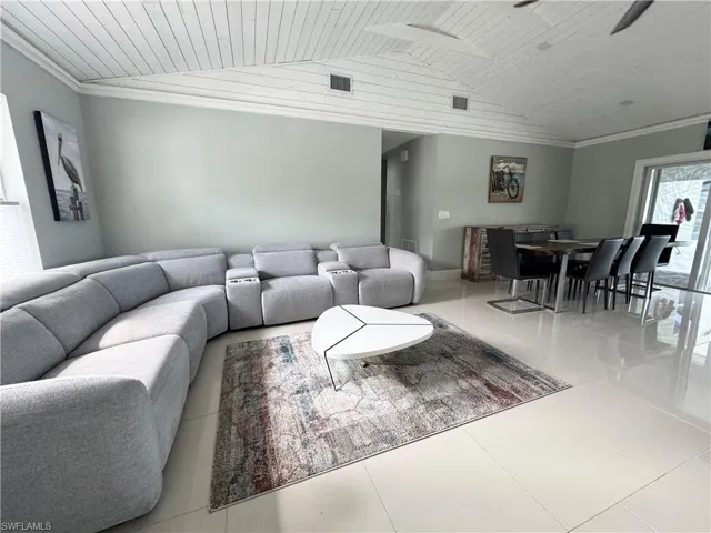 Living room featuring wood ceiling, tile patterned flooring, and vaulted ceiling