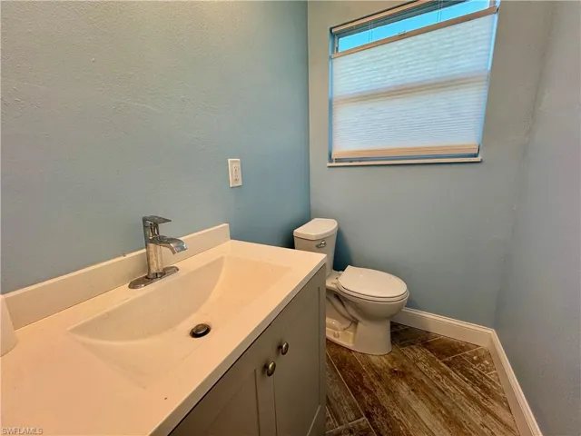 Bathroom featuring hardwood / wood-style flooring, vanity, and toilet