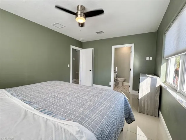 Tiled bedroom with ceiling fan and ensuite bathroom