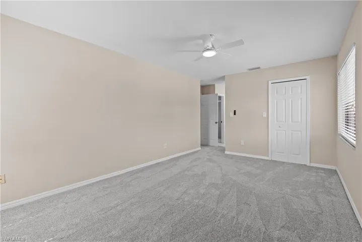 Empty room with light carpet and ceiling fan