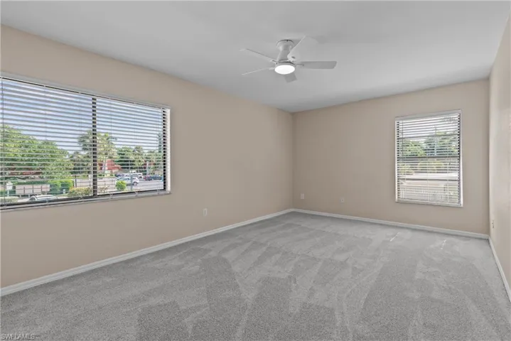 Spare room featuring light colored carpet and ceiling fan