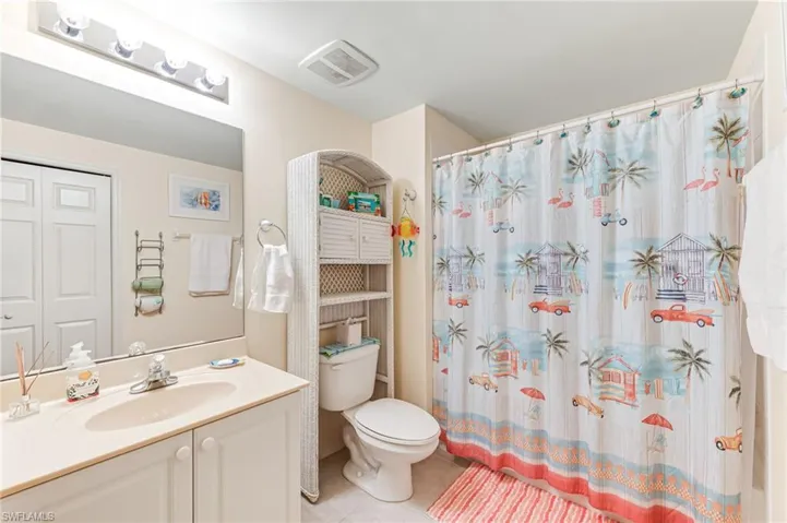 Bathroom featuring vanity, visible vents, toilet, a shower with shower curtain, and tile patterned floors