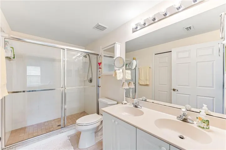 Full bath featuring a sink, visible vents, and a stall shower