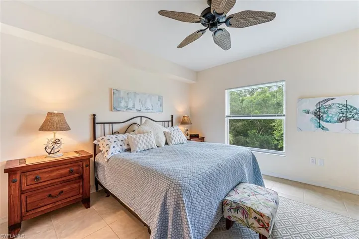 Bedroom with light tile patterned flooring, baseboards, and a ceiling fan