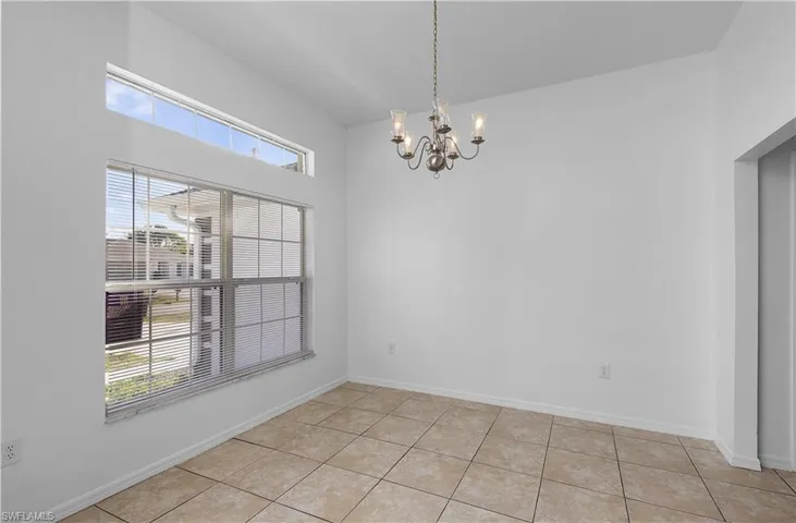 Unfurnished dining area with light tile patterned flooring and a chandelier