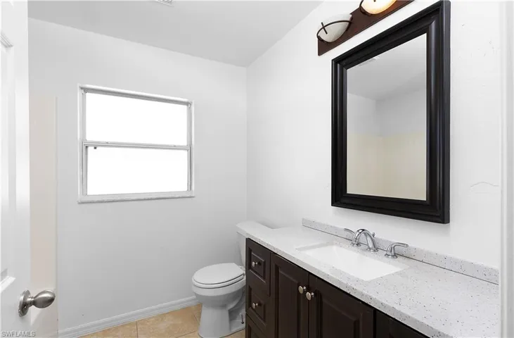 Bathroom with tile patterned floors, vanity, and toilet