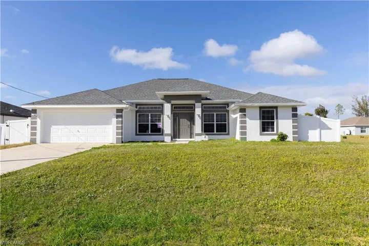 View of front of house featuring a garage and a front lawn