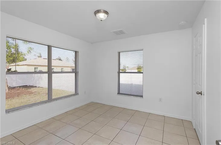 Spare room featuring light tile patterned flooring and a healthy amount of sunlight