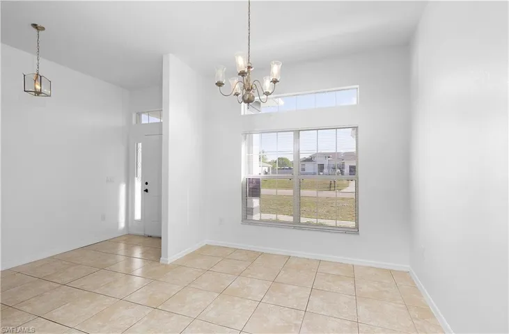Unfurnished dining area with a notable chandelier and light tile patterned floors