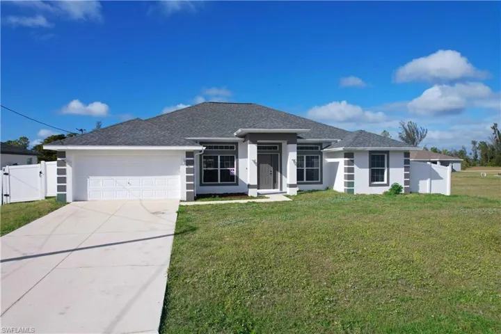 View of front of home featuring a front yard and a garage