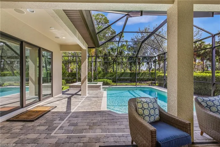 Relaxing pool / spa featuring a patio area, screen in lanai and putting green