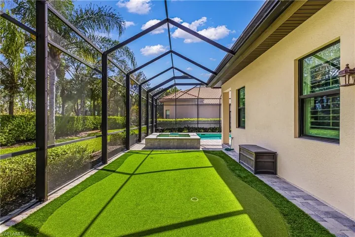 Relaxing pool / spa featuring a patio area, screen in lanai and putting green