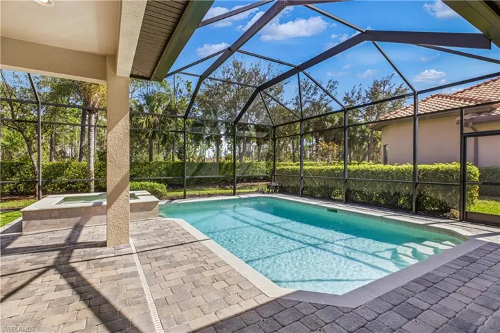 Relaxing pool / spa featuring a patio area, screen in lanai and putting green