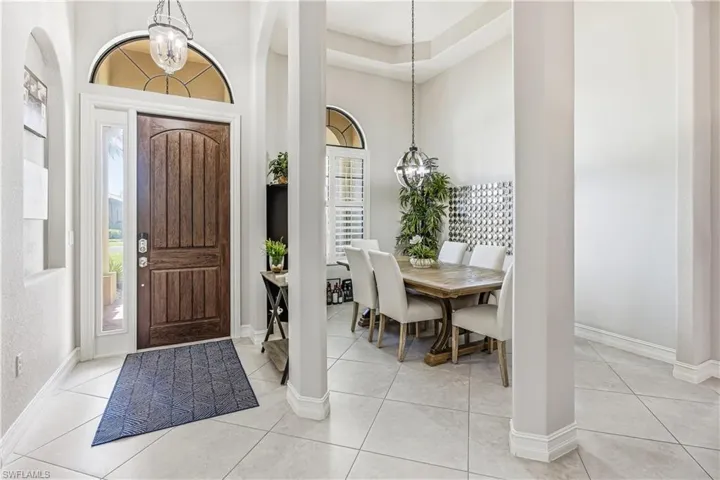 Foyer with hanging lights, a high ceiling, and light tile patterned floors