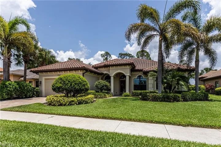 Mediterranean / spanish home with a front lawn, a garage, stucco siding, and driveway