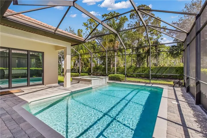 Relaxing pool / spa featuring a patio area, screen in lanai and putting green