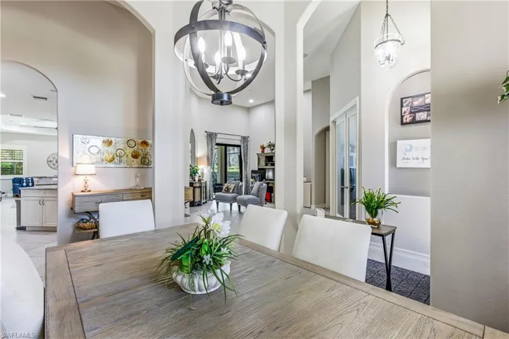 Dining room featuring arched walkways, a high ceiling, and a chandelier