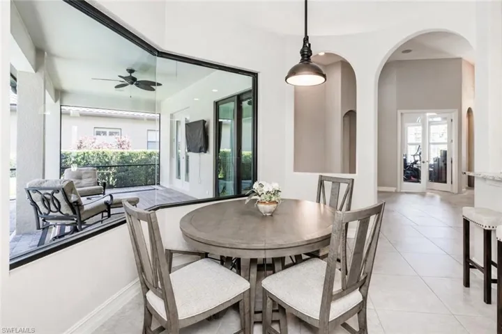 Dining room with light tile patterned flooring, a ceiling fan, and french doors