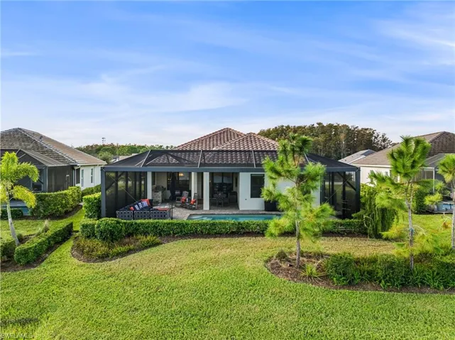 Rear view of house featuring a patio, a lawn, a pool, and glass enclosure