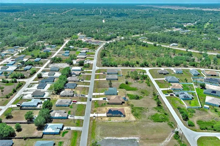 View of property location featuring a forest and nearby suburban area