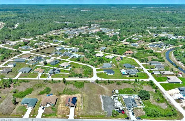 Aerial view of property's location with a heavily wooded area and nearby suburban area
