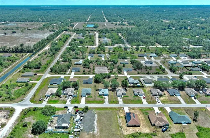 Aerial view of property and surrounding area featuring nearby suburban area