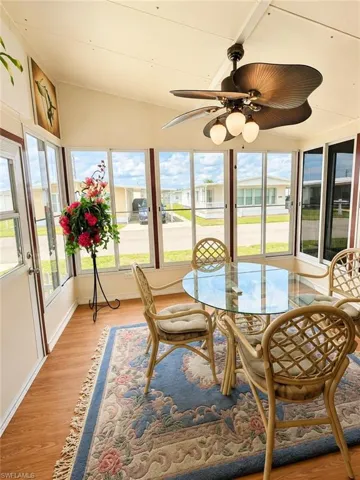 Sunroom featuring wood-finish flooring and a vaulted ceiling