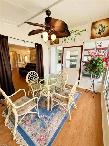 Sunroom featuring wood-finish flooring and a tropical-style ceiling fan with integrated lighting