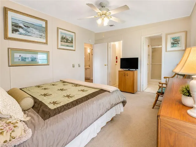 Carpeted bedroom with a ceiling fan